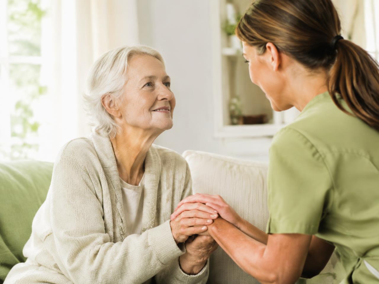 Caregiver holding an elderly woman's hands